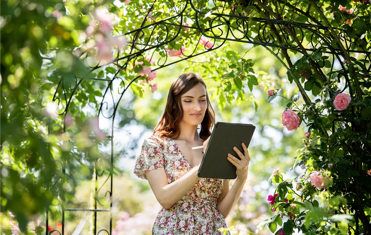 Frau mit Tablet im Garten