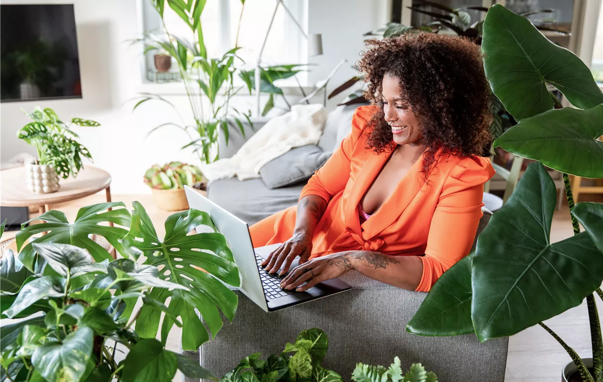 Jungle Ambiente - Frau im Wohnzimmer mit Laptop