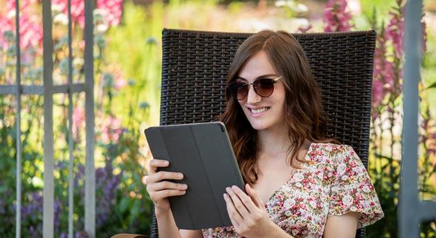 Frau mit Tablet im Garten