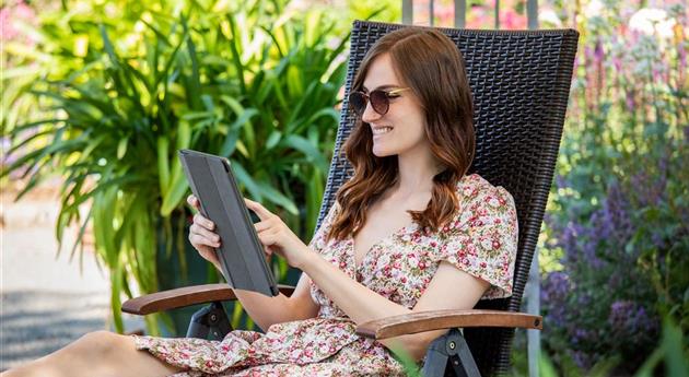 Frau mit Tablet im Garten