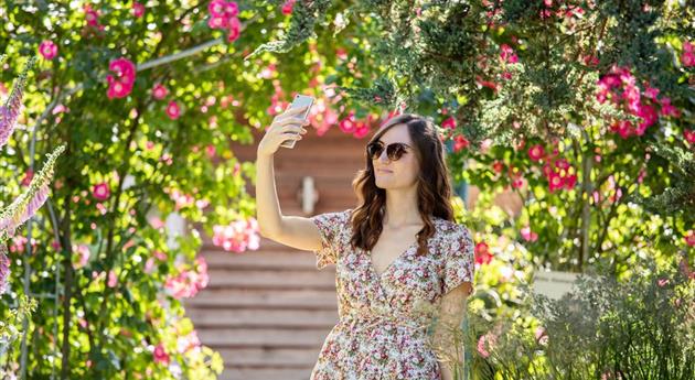 Frau mit Smartphone im Garten