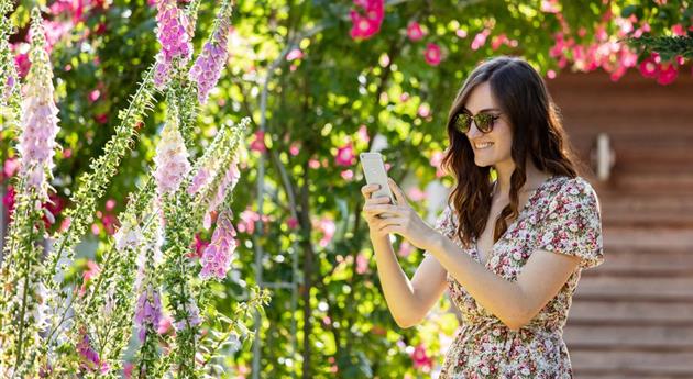 Frau mit Smartphone im Garten