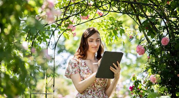 Frau mit Tablet im Garten