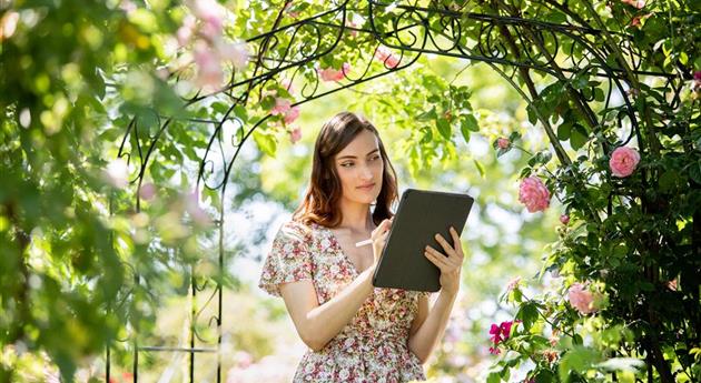 Frau mit Tablet im Garten