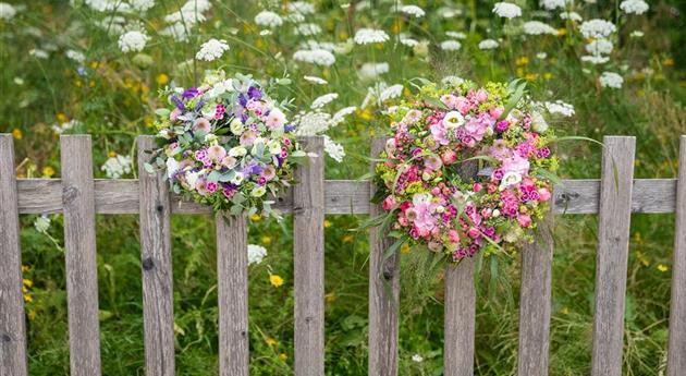 Blumenkränze am Holzzaun