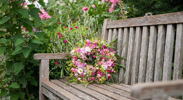 Blumenkranz auf Holzbank