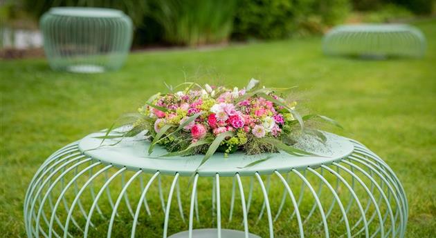 Blumenkranz auf Gartentisch