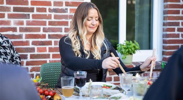 Grillen im Garten - Frau am Esstisch